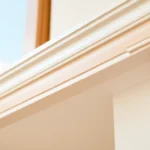 Finish trim installation in a contemporary living room, showcasing detailed woodwork and a flawless finish for a luxurious look.